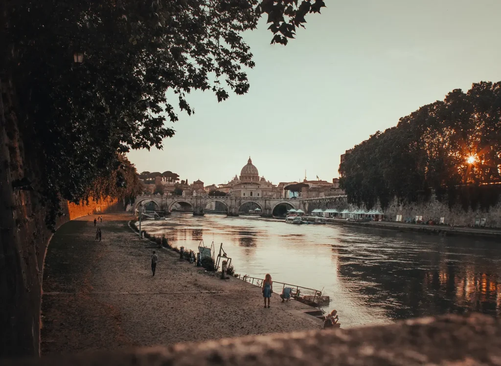 beautiful-shot-black-concrete-pathway-beside-body-waterin-rome-italy-sunset